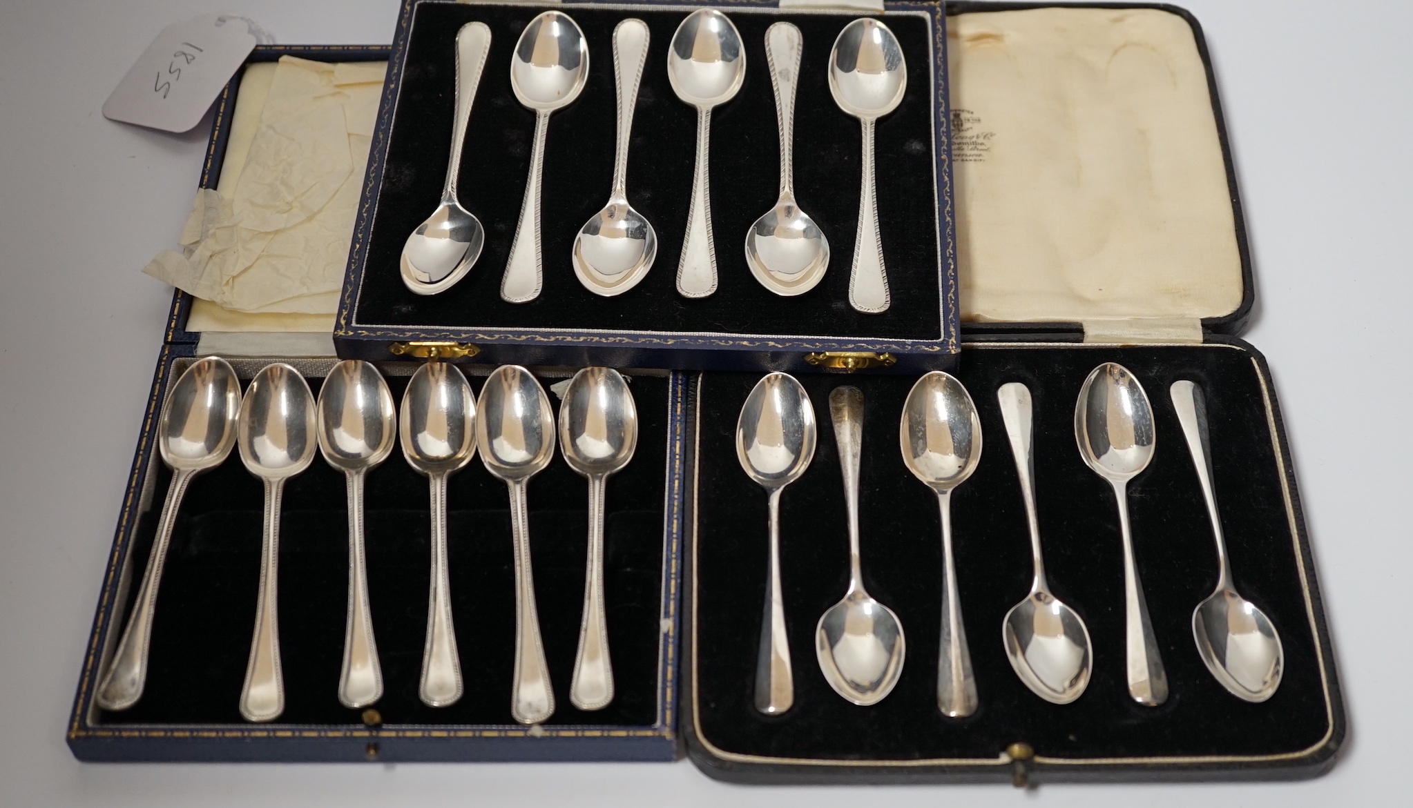 Three assorted cased sets of six silver tea or coffee spoons including Old English feather edge pattern.